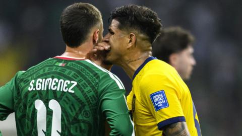 Ecuador's Piero Hincapie covers his mouth while speaking to Mexico's Santiago Gimenez