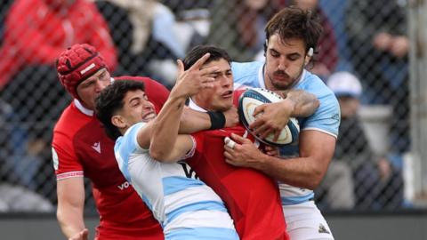 Louis Rees-Zammit of Wales is tackled by Simon Benitez Cruz of Argentina