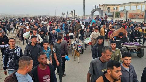 Displaced Palestinians return from a food distribution centre in Rafah, in the southern Gaza Strip, on 1 June 2025