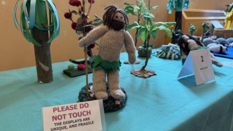 A knitted scene from the Bible depicting Adam and Eve in the Garden of Eden.