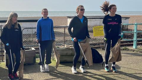 Runners on brighton seafront with sacks and litter pickers