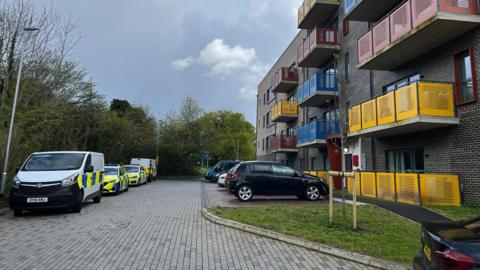 Police vehicles outside Juniper Square