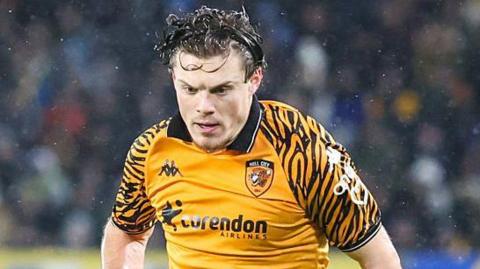Regan Slater looking towards the ground as he runs on the pitch during a game for Hull City this season