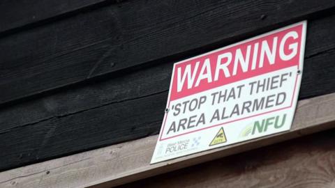 A warning sign to thieves tells that this farm is alarmed.
