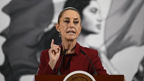 An image of President of Mexico Claudia Sheinbaum in a red suit. 