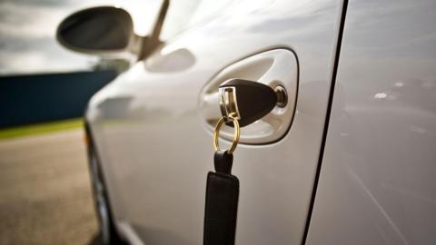 Close up of a key in a car door.