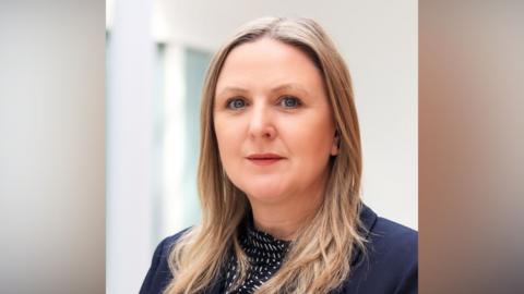 Sam Dennis is pictured. She is a white woman with long blond hair.