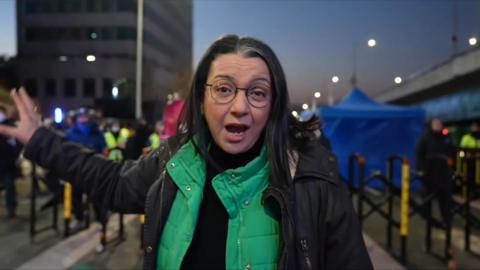 Shaimaa Khalil stands in front of police and protesters at dawn