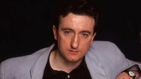 A close up of a man in a blazer.