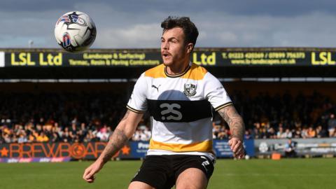 Mitch Clark watches the ball carefully as he prepares to control it during a match.