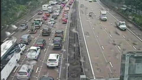 Traffic builds up on one side of a duel carriageway. On the other side, vehicles drive freely