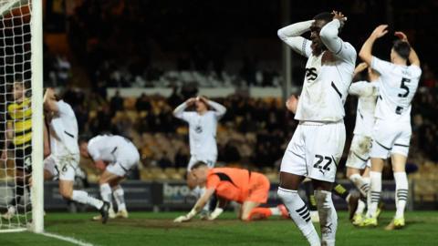 Port Vale players have their heads in their hands after a chance against Barrow goes begging