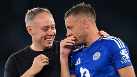 Steve Cooper and Jamie Vardy talk and smile as they come off the pitch. Vardy supported Cooper during his time at Leicester.