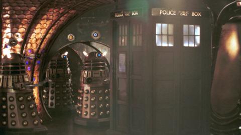 Exterior image of the Tardis and 3 Daleks 