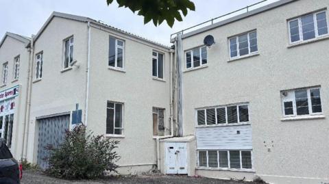 A white complex of buildings with windows and a garage.