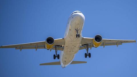 Picture of the underside of an unmarked plane coming in to land