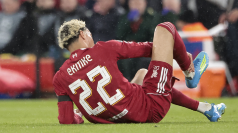 Hugo Ekitike holds his ankle on the ground