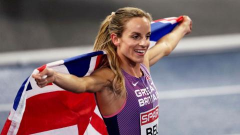 Georgia Bell holding up a GB flag behind her