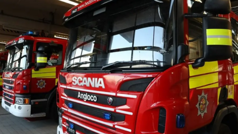A close up of red fire engines which are waiting to attend an incident. They are parked up at the station.