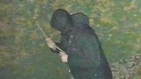 Undated screen grab taken from CCTV issued by West Midlands Police of John Ashby holding a stick