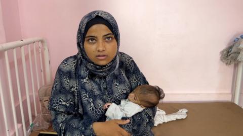 Mother holds baby at Gaza Nasser Hospital
