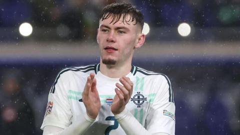 NI scorer Conor Bradley acknowledges the fans after the game