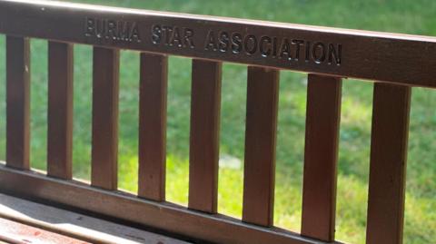 The words Burma Star Association carved into the back of a memorial bench in the arboretum.