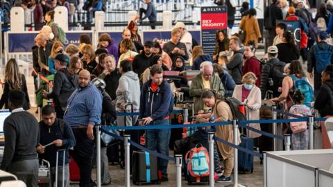 Travellers are lined up at an aiport