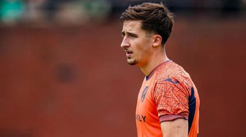 Louie Moulden wearing a Norwich City orange goalkeeper's kit during a pre-season friendly in July 2025