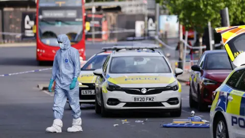 Body-worn footage showing a police officer's arm holding a Taser, another officer to the left and the knife suspect walking towards them