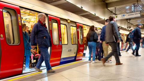People getting off the tube at a station on the Jubilee line photo taken from the platform