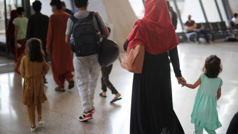 A group of people including women and children arriving at Dulles airport after fleeing the Taliban takeover of Afghanistan August 27, 2021.