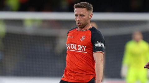 Jordan Clark looks downwards to the ball during a match.