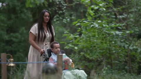 Mum Kareema and son Jayden in the garden with Jayden in a wheelchair