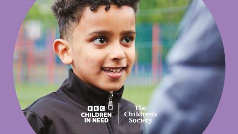 A boy smiles with Children and Need branding.