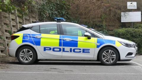 Police car with 'police' in blue font, viewed side on