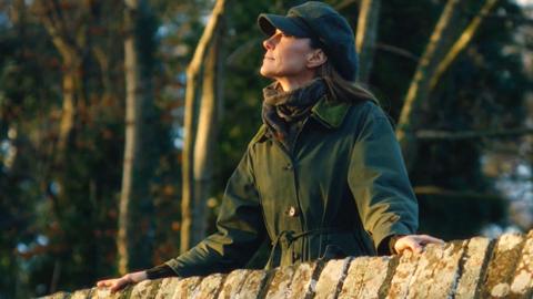 Princess of Wales on a bridge in a coat on a walk in the countryside