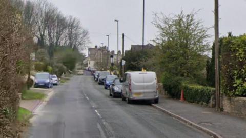 Bloomfield Road in Bath on a grey day, with vehicles parked on either side of the road