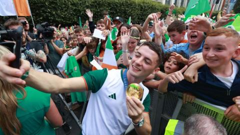 Gymnast Rhys McClenaghan takes a selfie with a fan during Team Ireland's homecoming ceremony in Dublin 