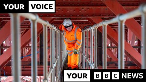 Man in orange hi-vis and white hard hat, underneath the railway line on the Forth Bridge