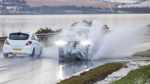 Vehicles drive on the A9 in Inverness, as snow, rain and wind warnings are in force and are expected to cause travel issues on New Year's Eve.