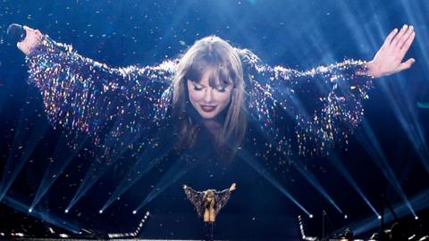 Taylor Swift takes a bow on stage in Canada, wearing a tinselled jacket