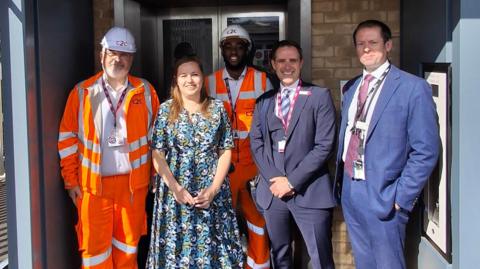 Four men and one woman standing in front of the new lift 