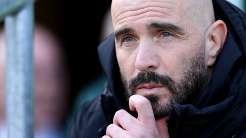 Enzo Maresca sits in the dugout during a Leicester City match