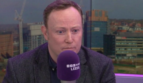 A man talks into a microphone in a BBC studio.