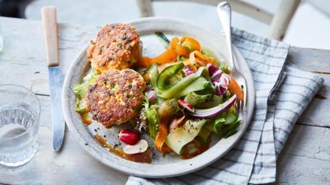 Thai salmon fish cakes served with salad on a white plate