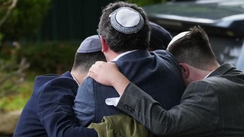 Worshippers gather near the scene of the attack