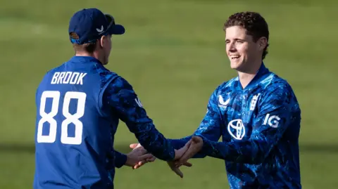 England players Harry Brook (left) and Jacob Bethell (right) celebrate a wicket