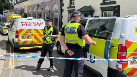 Police officers standing next to a cordoned-off area in Church Street, Welshpool