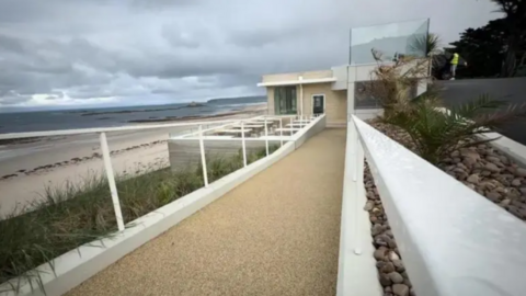 Looking along the path leading to the restaurant which is on the seafront above the beach
